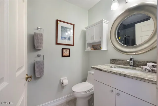 a bathroom with a toilet a sink and mirror