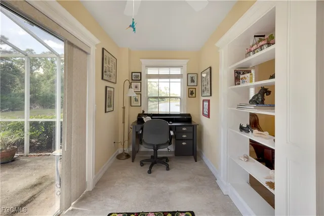 a view of a bedroom with workspace and windows