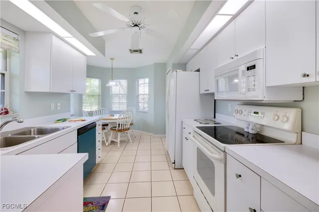 a kitchen with a sink a stove a refrigerator and cabinets