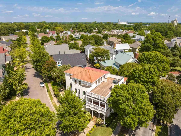 an aerial view of residential houses with outdoor space and trees