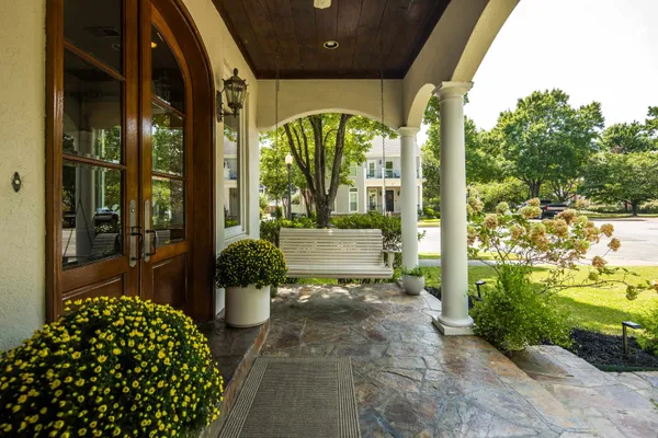a view of a porch with chairs and potted plants