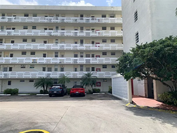 a view of a building with cars parked