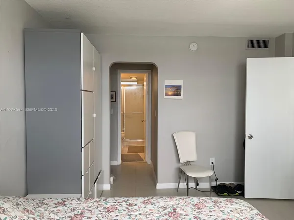 a view of a bedroom with a table and chair