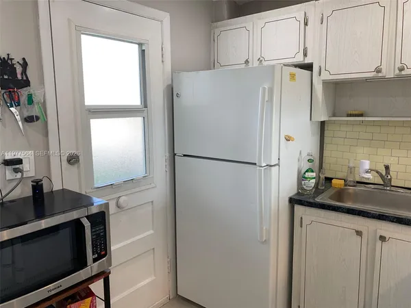 a kitchen with appliances a sink and cabinets