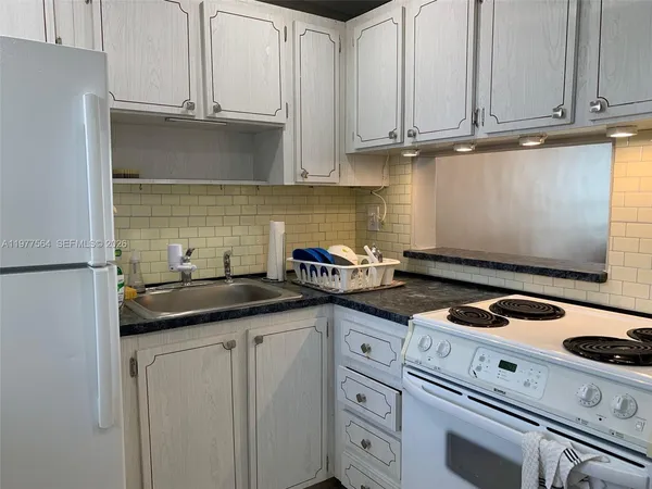 a kitchen with granite countertop a sink and cabinets
