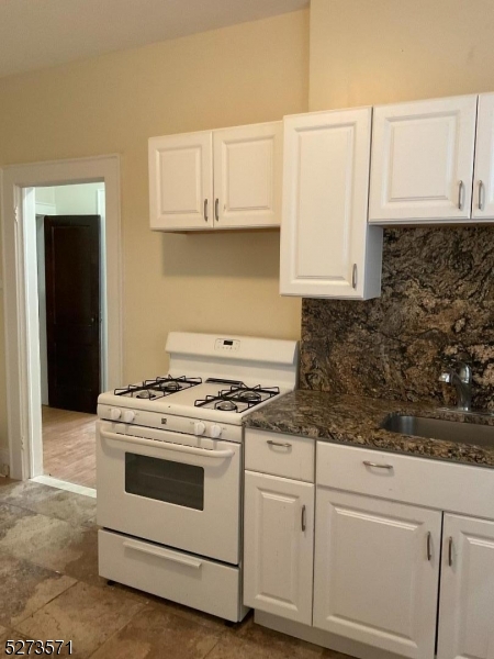 a white stove top oven sitting inside of a kitchen