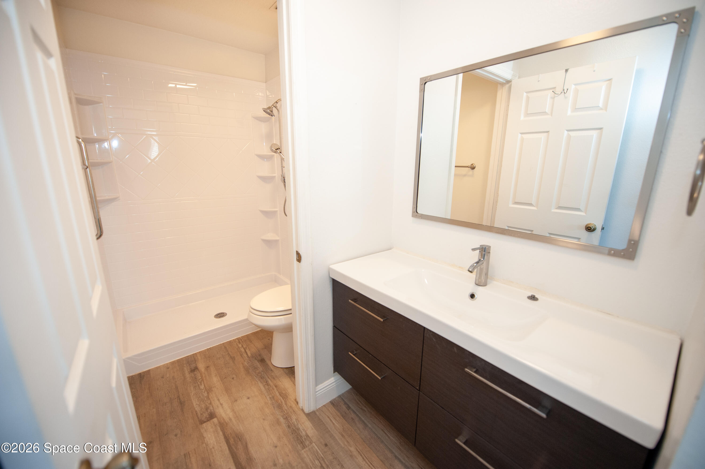 1942 Quail Ridge Court, Unit 504 Cocoa, FL 32926 - Photo 10 of 27 a bathroom with a sink a toilet and shower