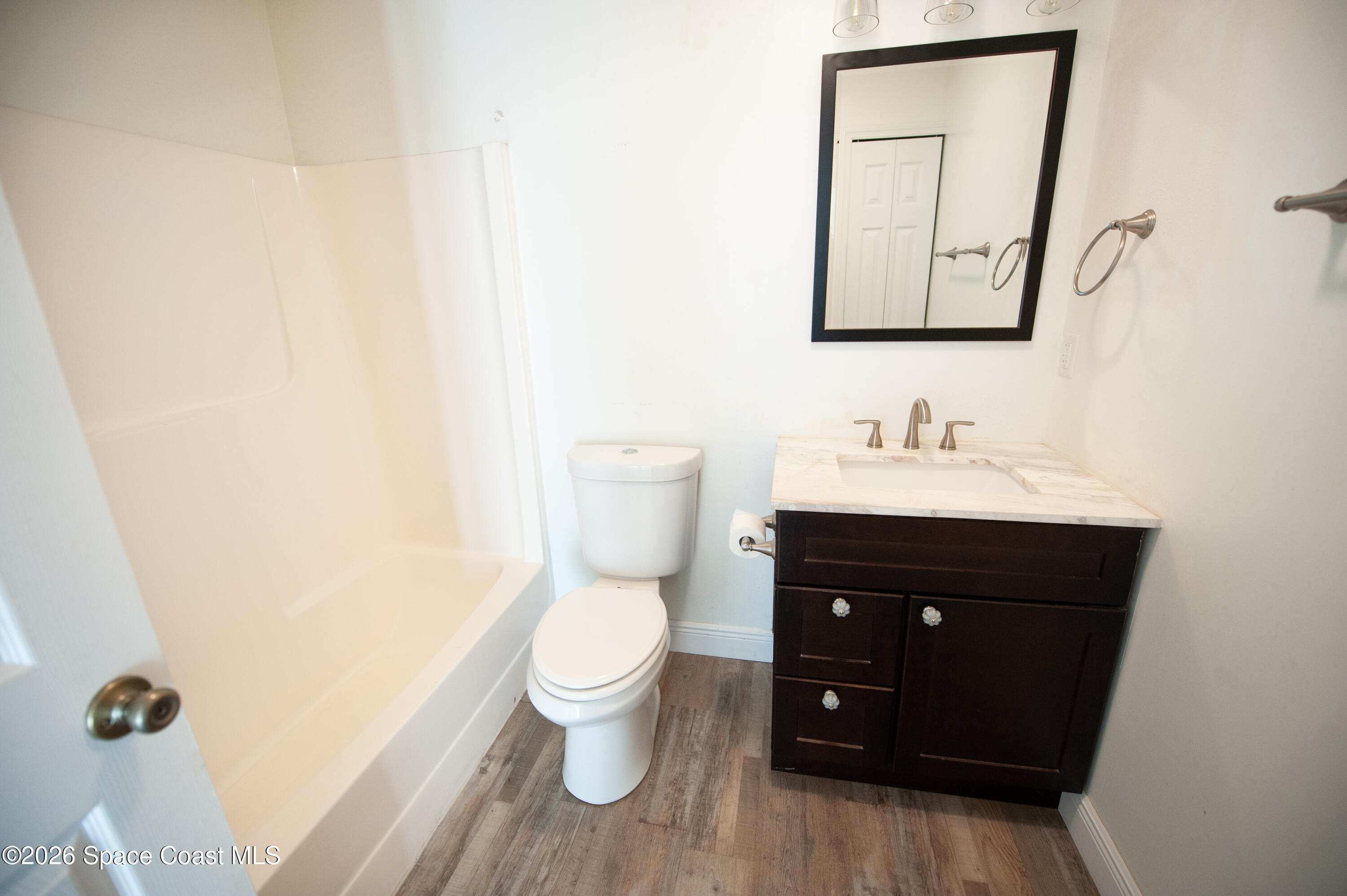1942 Quail Ridge Court, Unit 504 Cocoa, FL 32926 - Photo 15 of 27 a bathroom with a toilet sink and mirror