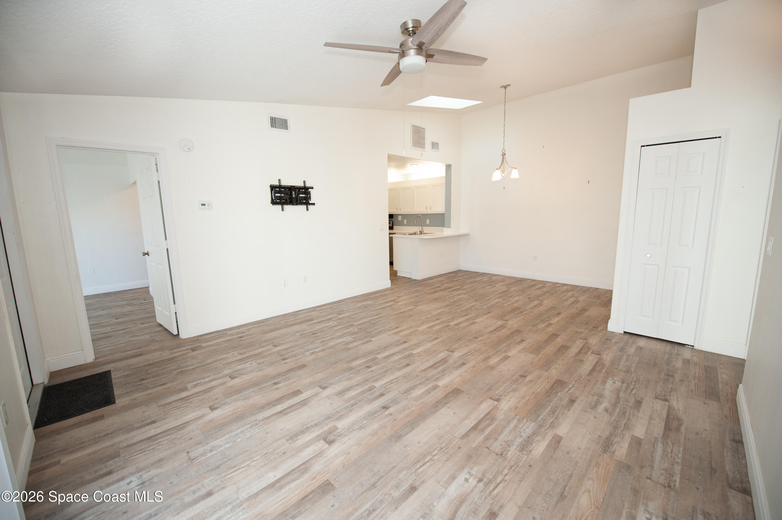 1942 Quail Ridge Court, Unit 504 Cocoa, FL 32926 - Photo 2 of 27 wooden floor in an empty room with a window