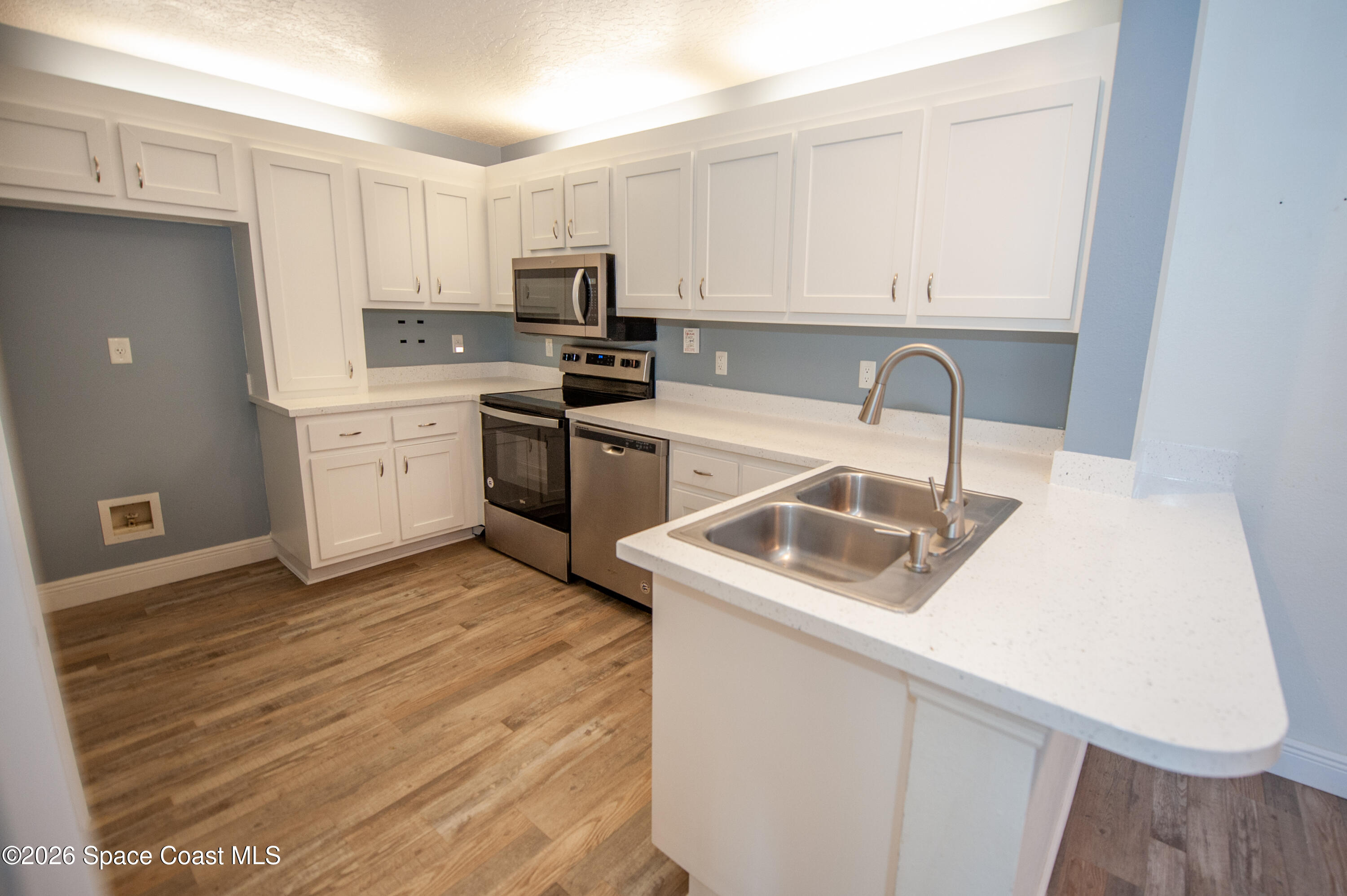 1942 Quail Ridge Court, Unit 504 Cocoa, FL 32926 - Photo 3 of 27 a kitchen with a sink a stove and cabinets