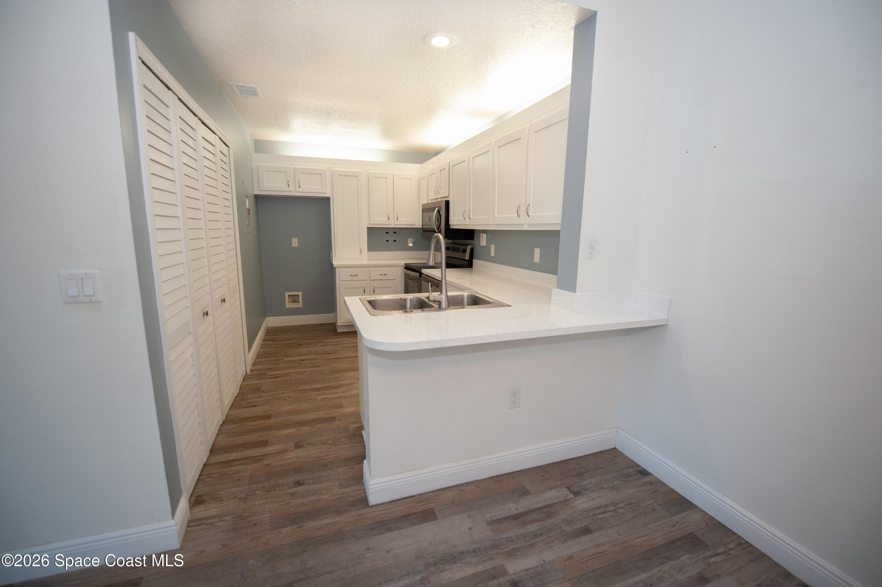 1942 Quail Ridge Court, Unit 504 Cocoa, FL 32926 - Photo 4 of 27 a bathroom with a sink a mirror and vanity