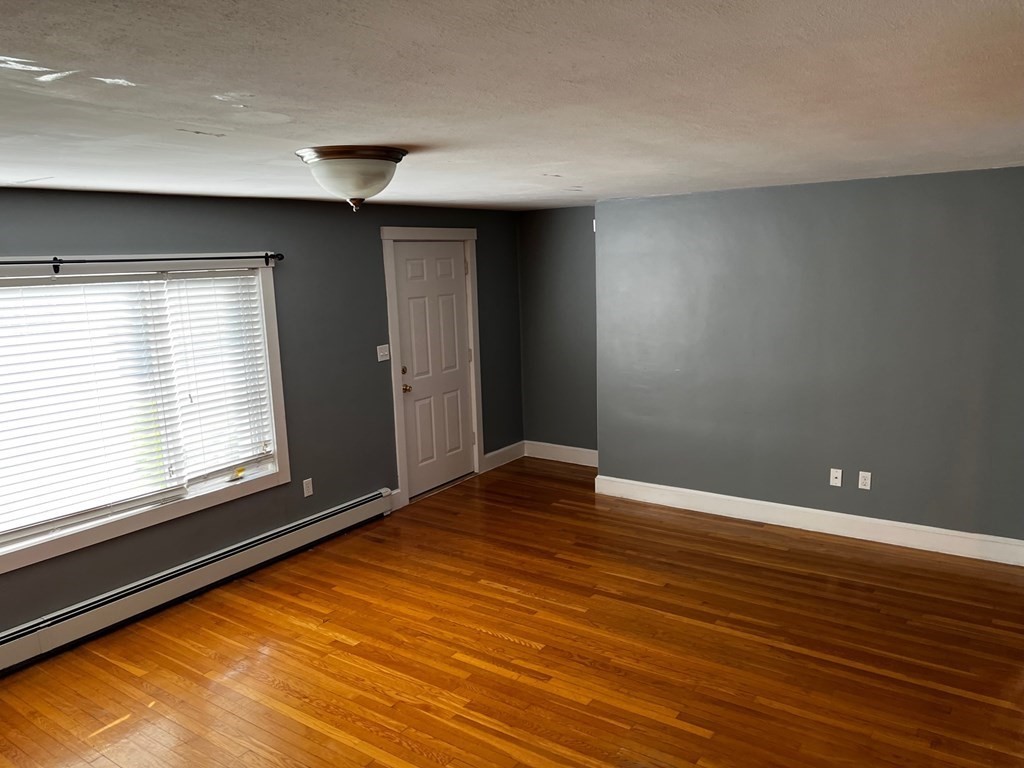 196 Boston Road Chelmsford, MA 01824 - Photo 11 of 26 a view of an empty room with window and wooden floor