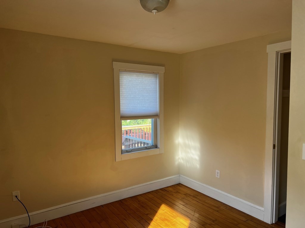 196 Boston Road Chelmsford, MA 01824 - Photo 16 of 26 an empty room with a window and wooden floor