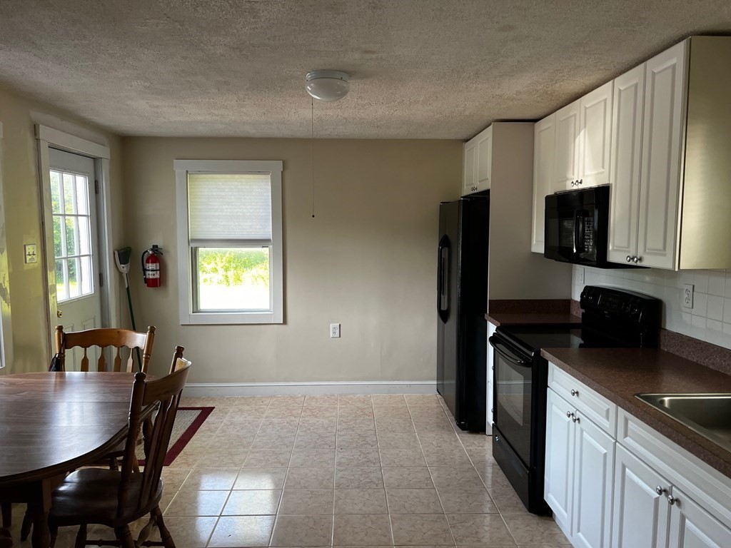 196 Boston Road Chelmsford, MA 01824 - Photo 5 of 26 a kitchen with stainless steel appliances granite countertop a stove a refrigerator a sink a dining table and chairs