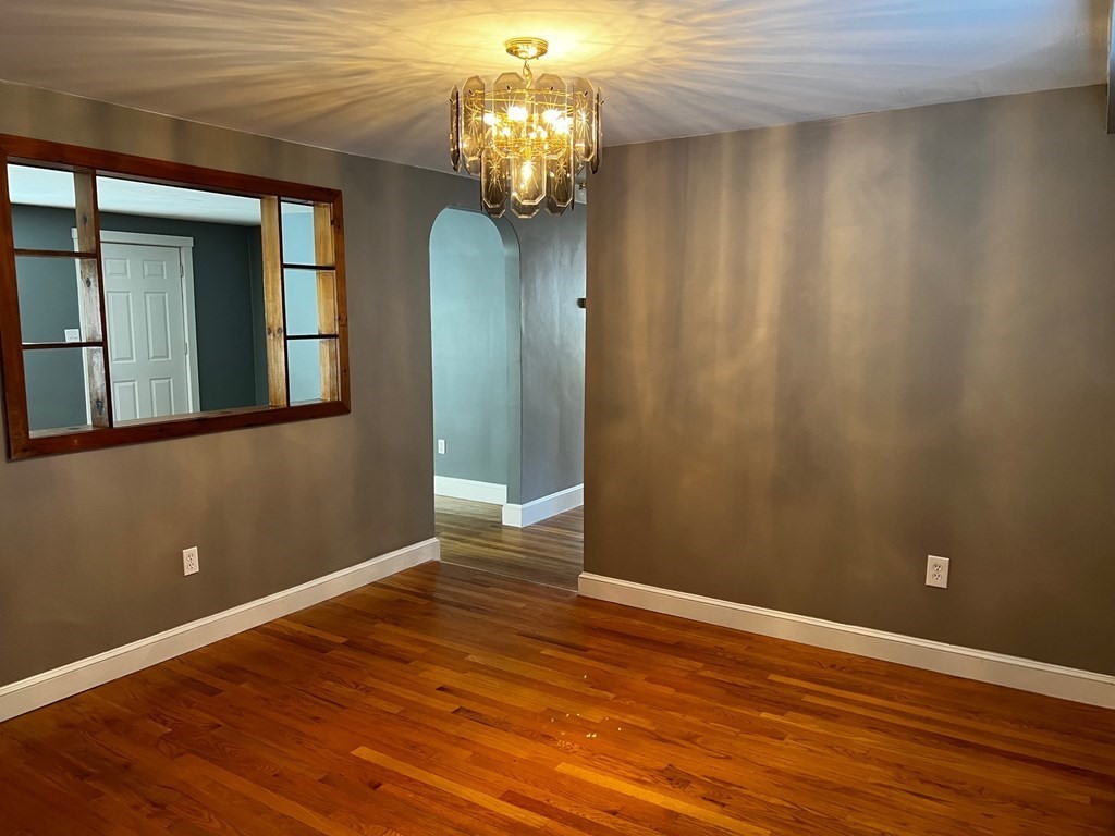 196 Boston Road Chelmsford, MA 01824 - Photo 8 of 26 a view of a hallway with wooden floor and a chandelier