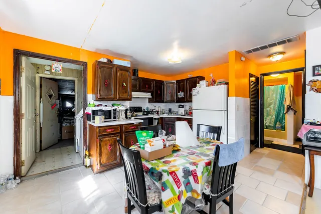 a view of a dining room with furniture one side kitchen view and a window