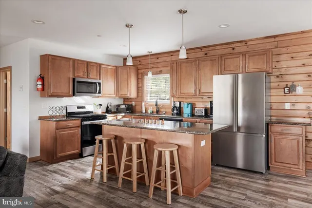 a kitchen with stainless steel appliances granite countertop a refrigerator a stove top oven a sink and dishwasher