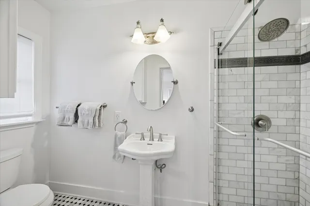 a bathroom with a sink a toilet and shower