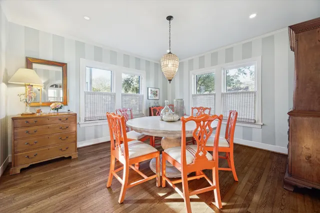 a dining room with furniture a chandelier and wooden floor