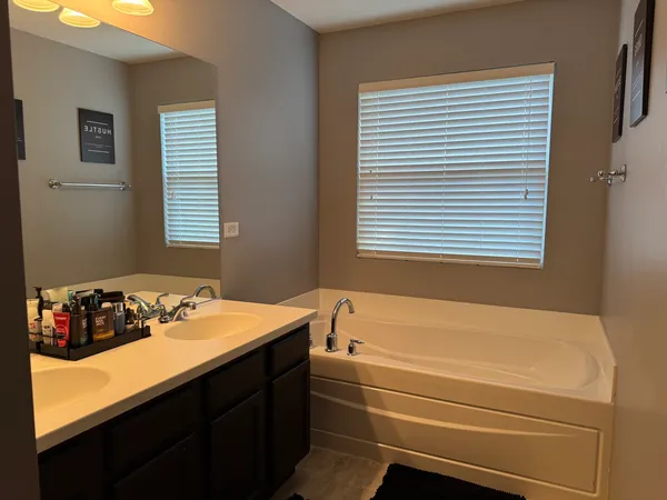 a bathroom with a tub sink and a window