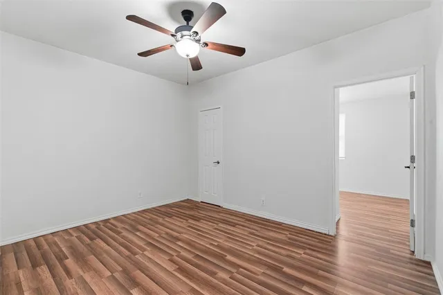 a view of a big room with wooden floor and a ceiling fan