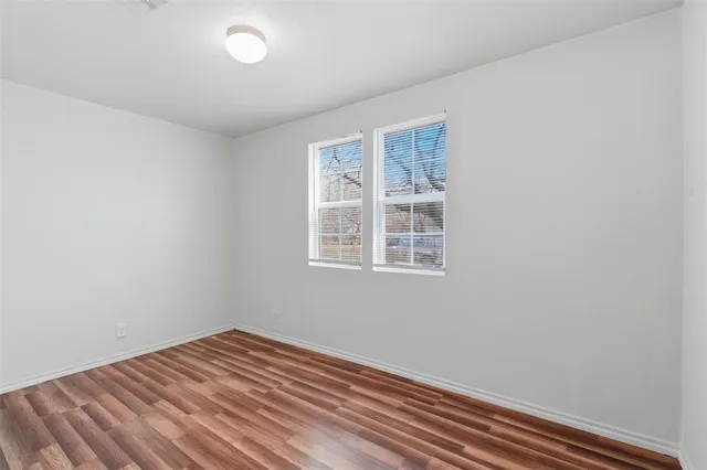 a view of a room with wooden floor and windows