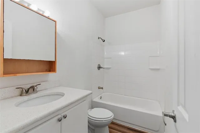 a bathroom with a granite countertop sink toilet and shower