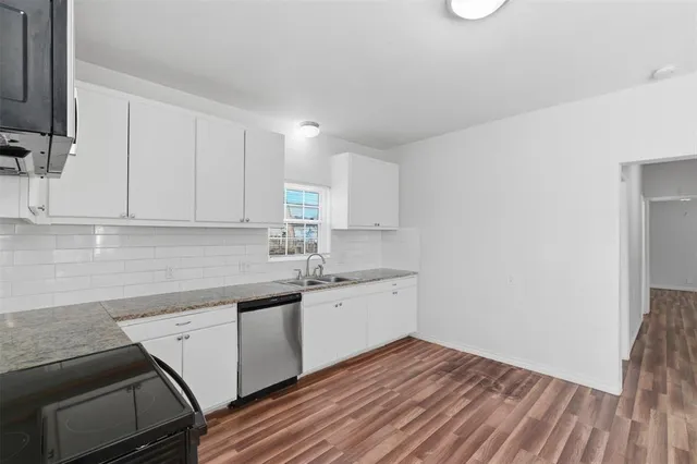 a kitchen with a sink window and cabinets