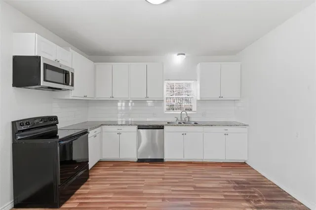 a kitchen with appliances a sink and cabinets