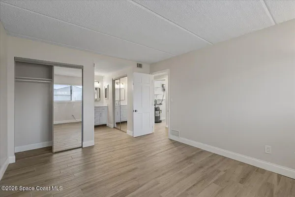 a view of empty room with wooden floor