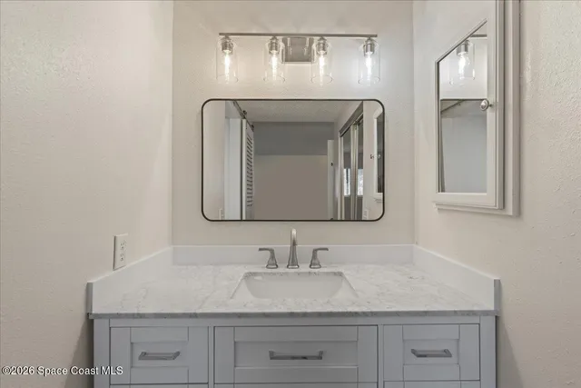 a bathroom with a sink vanity and mirror