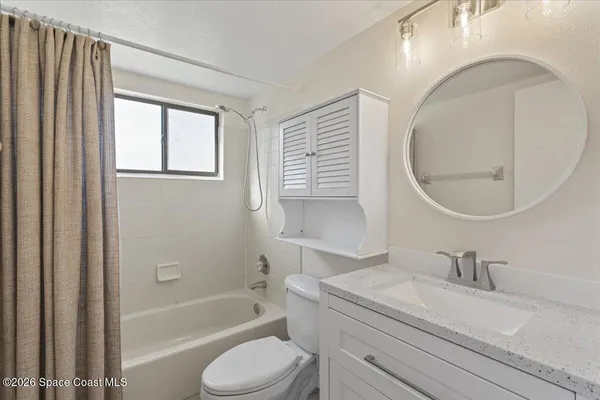 a bathroom with a granite countertop sink a toilet and a mirror