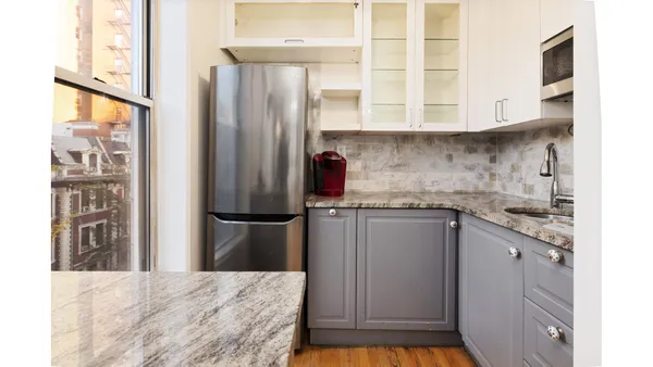 a kitchen with stainless steel appliances granite countertop a refrigerator and a stove top oven