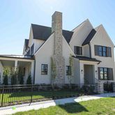 a front view of a house with a garden and plants