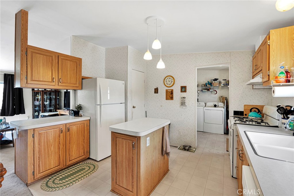 12837 Hacienda Road Phelan, CA 92371 - Photo 11 of 51 a kitchen with stainless steel appliances a refrigerator a sink a stove and white cabinets