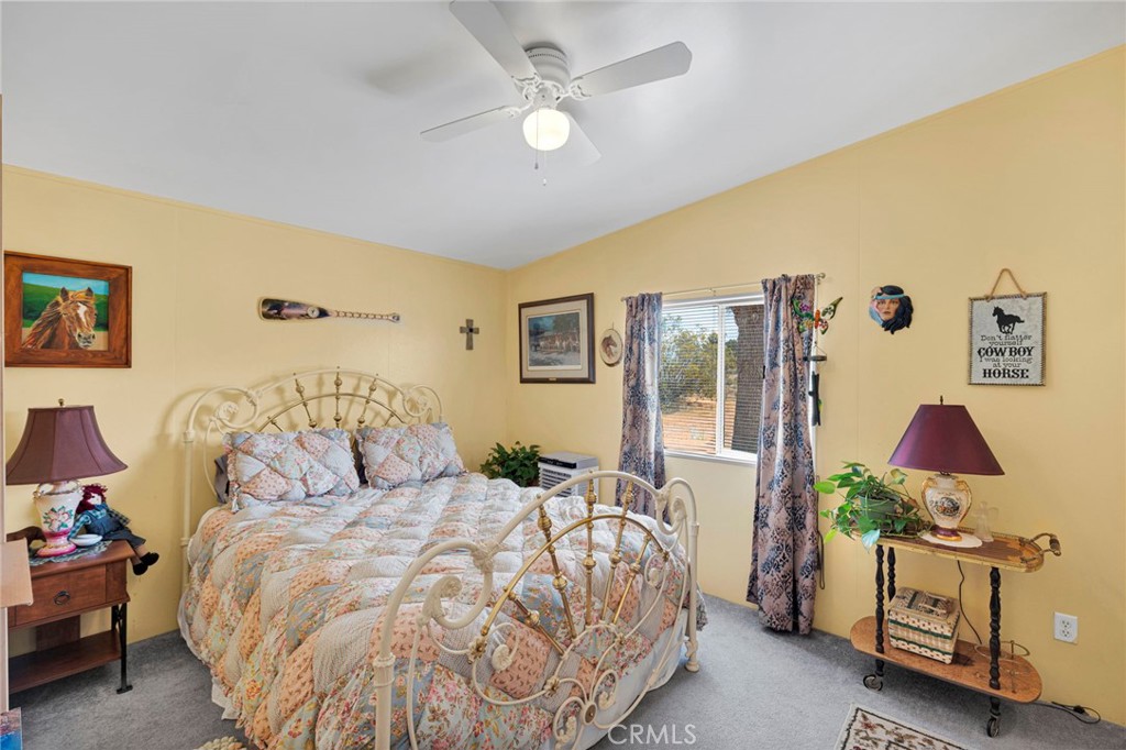 12837 Hacienda Road Phelan, CA 92371 - Photo 18 of 51 a bedroom with a bed and a chandelier