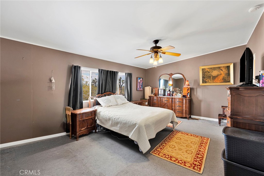 12837 Hacienda Road Phelan, CA 92371 - Photo 22 of 51 a bed room with a bed and a chandelier