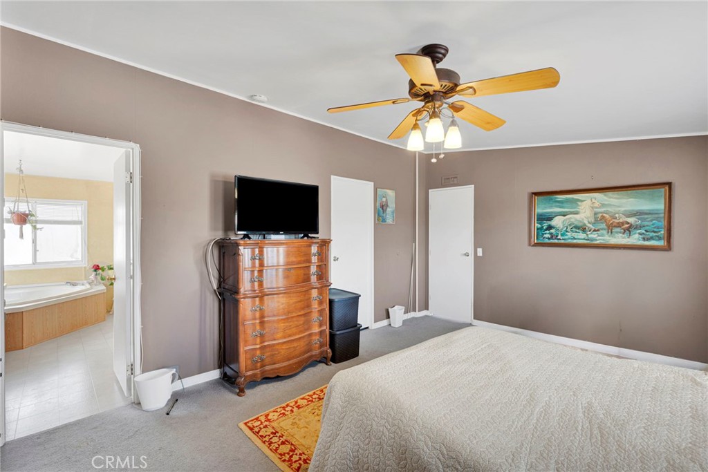 12837 Hacienda Road Phelan, CA 92371 - Photo 23 of 51 a bedroom with a bed and a flat screen tv
