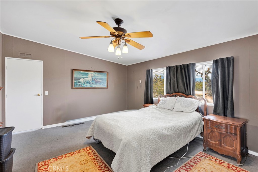 12837 Hacienda Road Phelan, CA 92371 - Photo 24 of 51 a bedroom with a bed and a chandelier