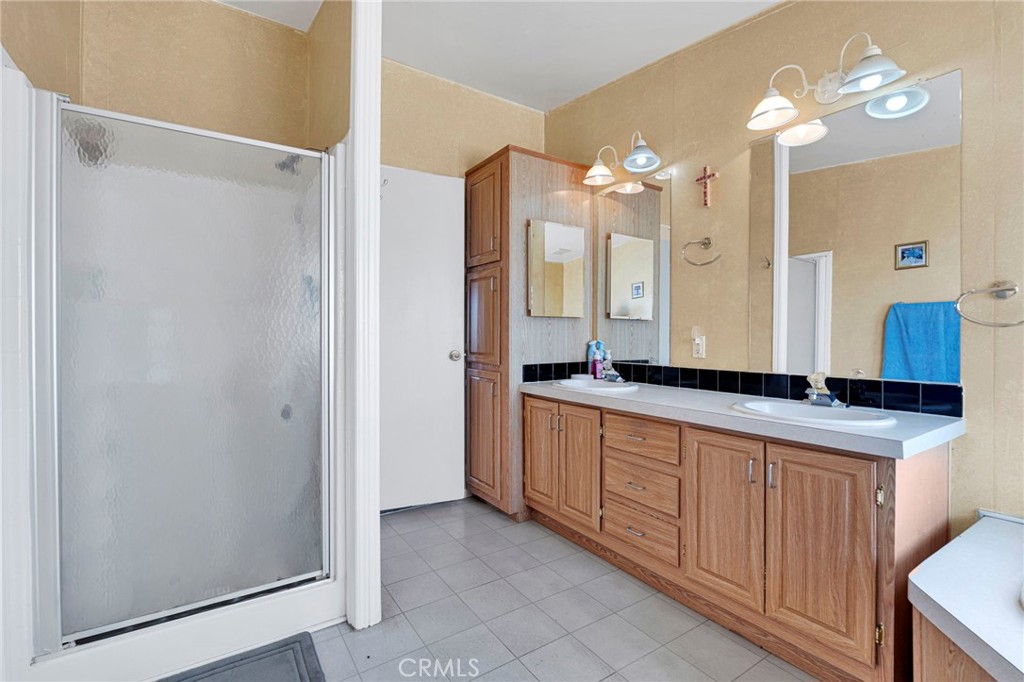 12837 Hacienda Road Phelan, CA 92371 - Photo 25 of 51 a bathroom with a double vanity sink and a mirror