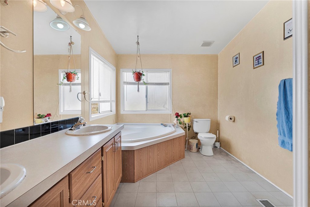 12837 Hacienda Road Phelan, CA 92371 - Photo 26 of 51 a bath room with a sink and a mirror