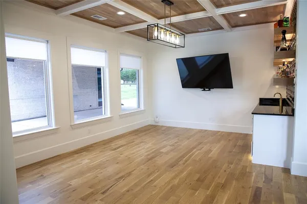 a spacious bedroom with a bed and a flat screen tv