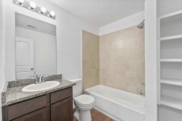 a bathroom with a granite countertop sink toilet and shower