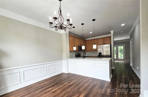 a view of a hallway with wooden floor and a ceiling fan