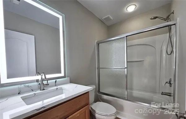 a bathroom with a sink toilet a mirror and shower