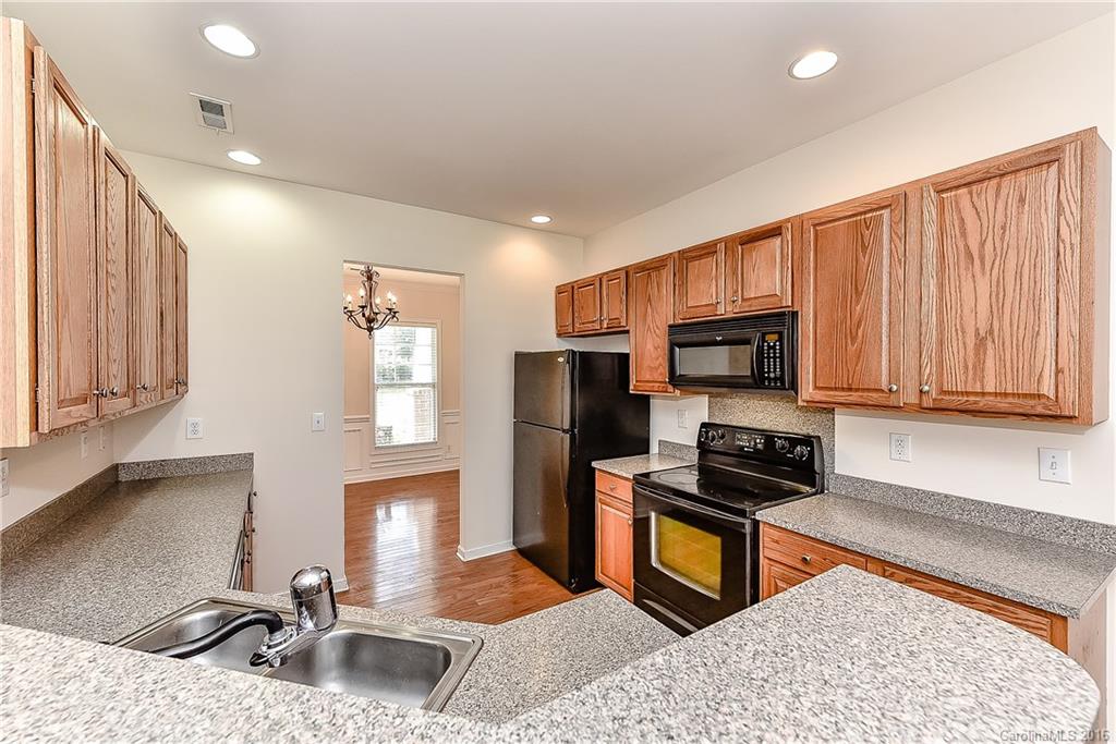 3111 Gloxinia Road Charlotte, NC 28215 - Photo 11 of 24 a kitchen with stainless steel appliances granite countertop a sink stove and refrigerator