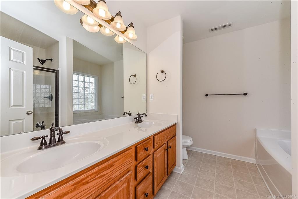 3111 Gloxinia Road Charlotte, NC 28215 - Photo 17 of 24 a bathroom with a sink a vanity and a mirror