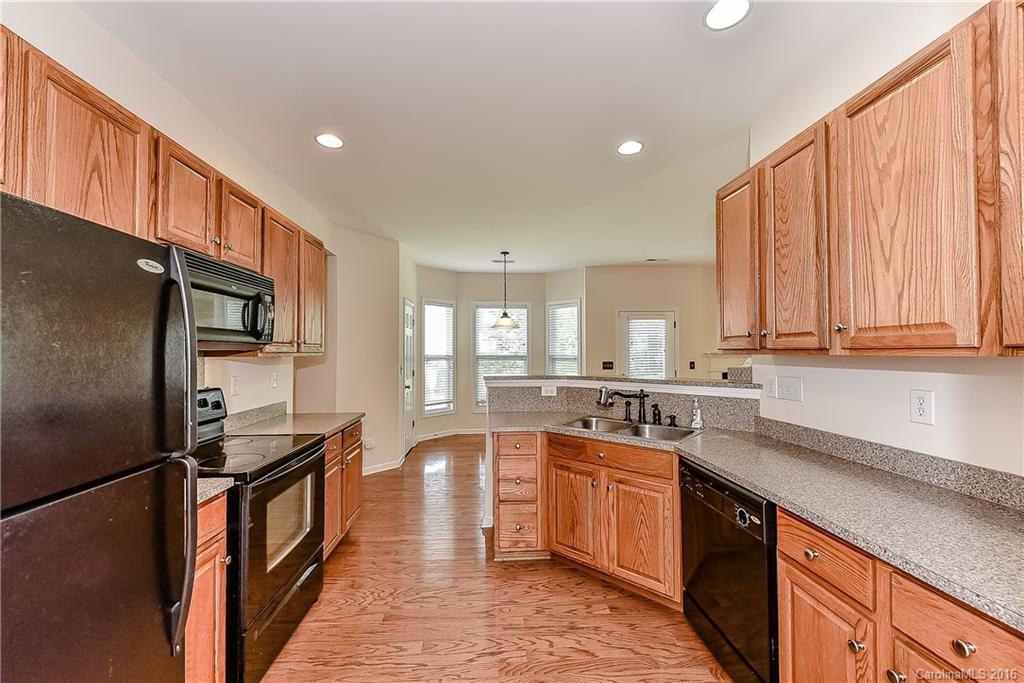 3111 Gloxinia Road Charlotte, NC 28215 - Photo 5 of 24 a kitchen with stainless steel appliances granite countertop a refrigerator a sink dishwasher a stove and white countertops with wooden floor