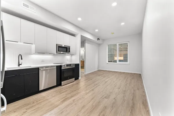 a kitchen with granite countertop a refrigerator and a stove top oven