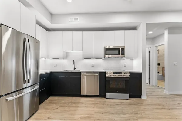 a kitchen with stainless steel appliances granite countertop a refrigerator stove and sink